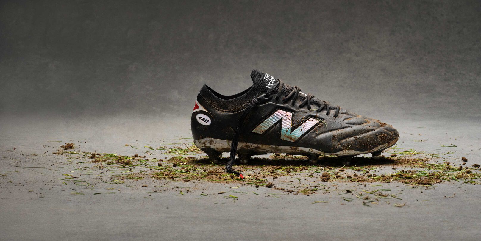 Black and white cleats with dirt on them