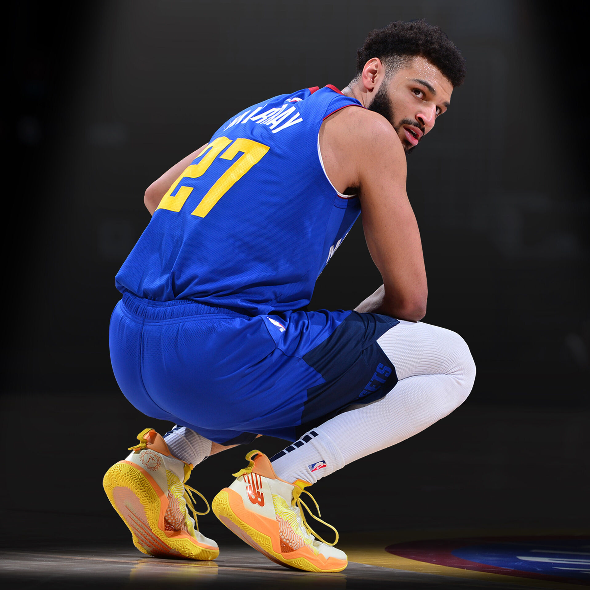 Jamal Murray, NBA basketball player, wearing a blue jersey and gold TWO WXY basketball shoes, squatting on a black background