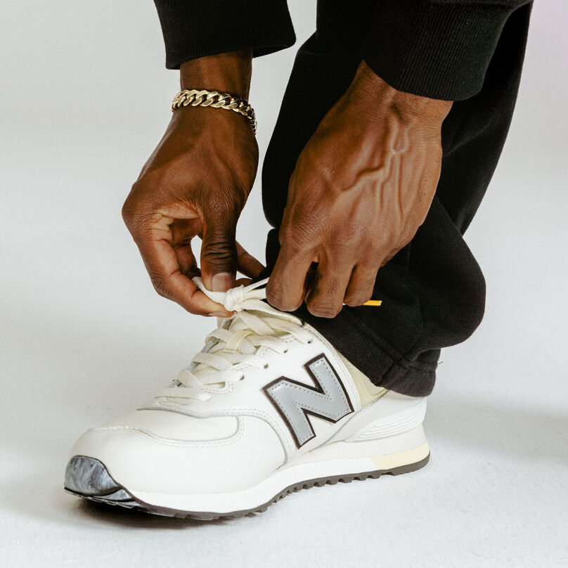 Close up image of Trayvon Bromell tying his laces on the CAU 574s