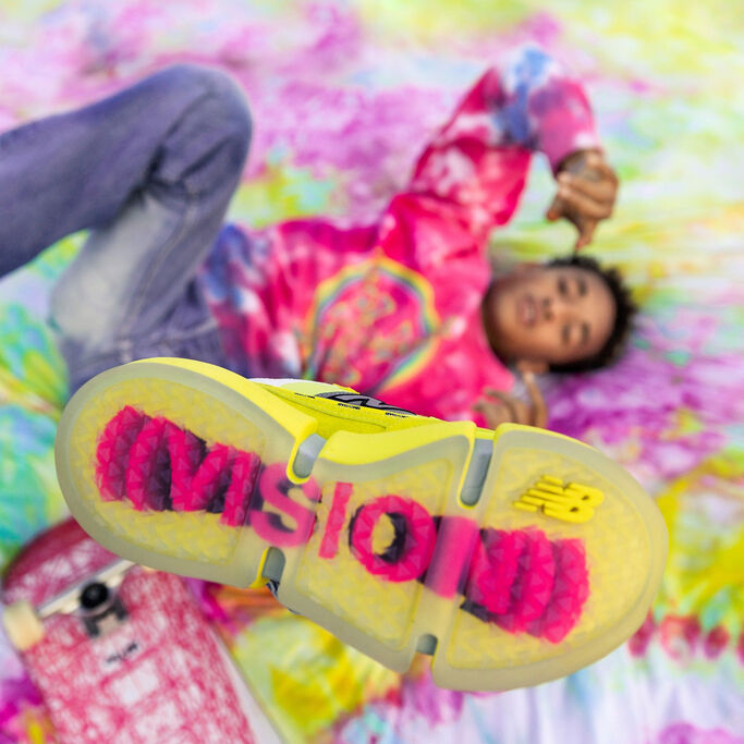 Jaden allongé sur une couverture teinture au nœud, son pied gauche en l'air montrant le dessous de la chaussure.