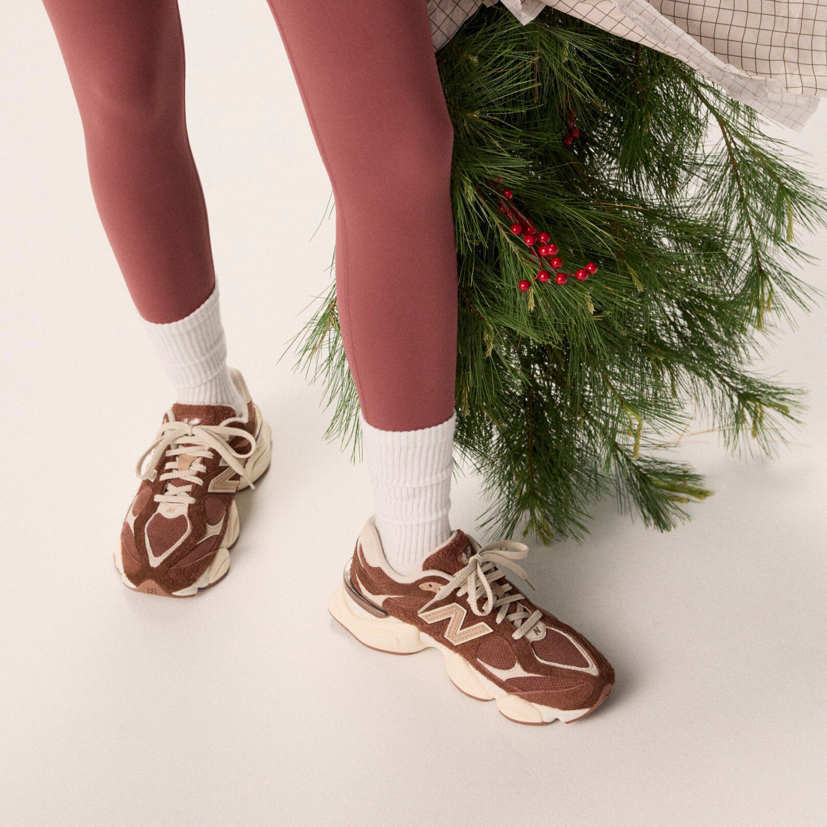 Jeune femme en collants bordeaux tenant un sac de guirlandes.