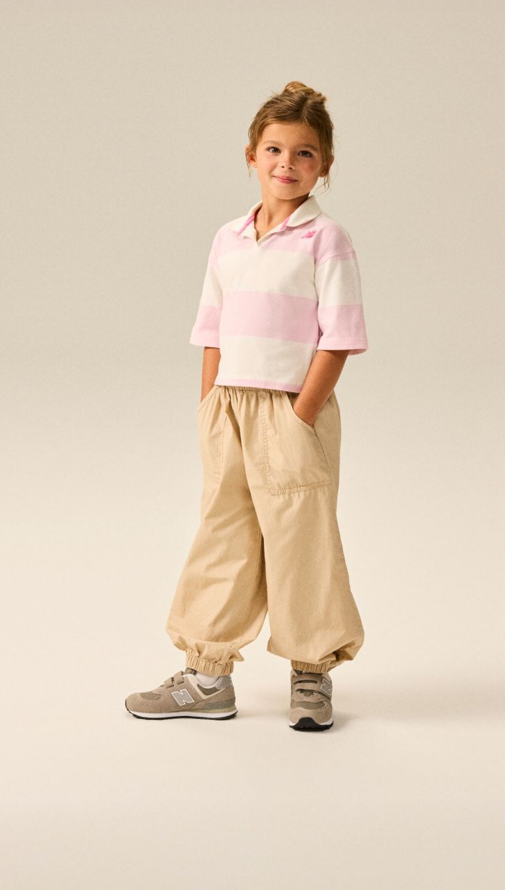 Girl wearing a pair of grey 574 shoes.