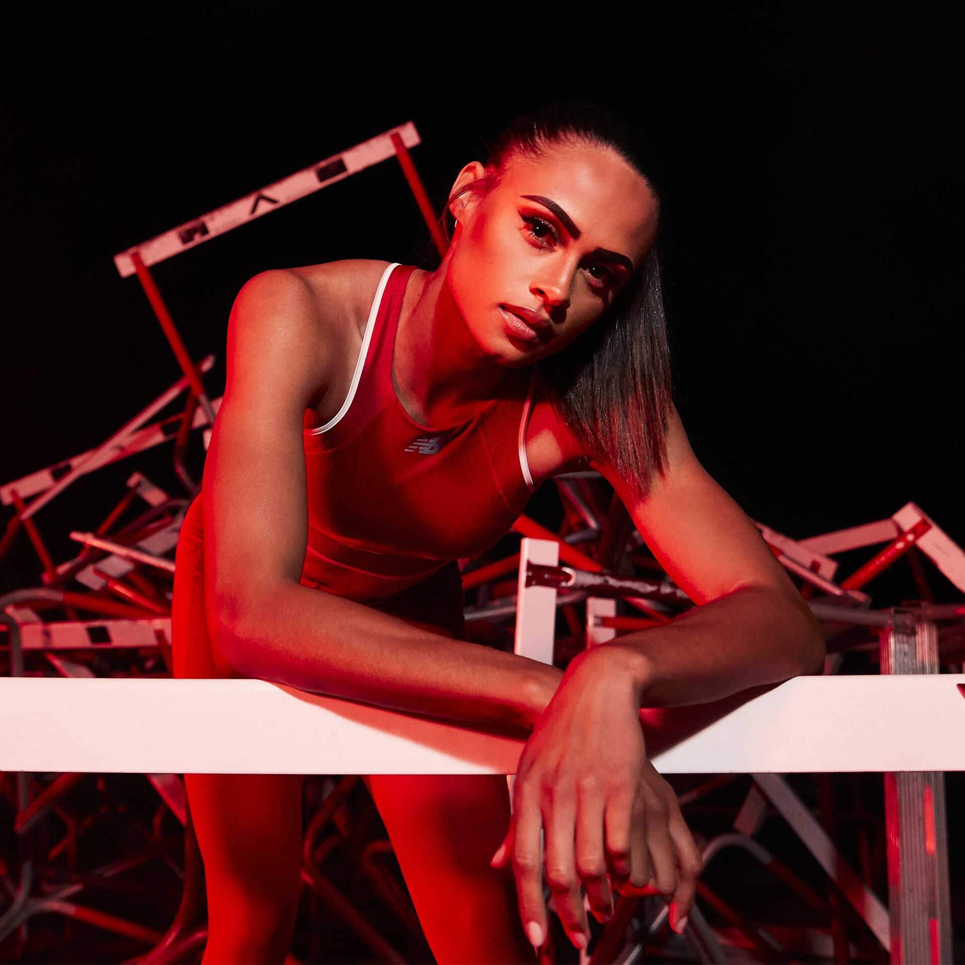 La coureuse Sydney McLaughlin sur la piste avec des obstacles empilés derrière elle