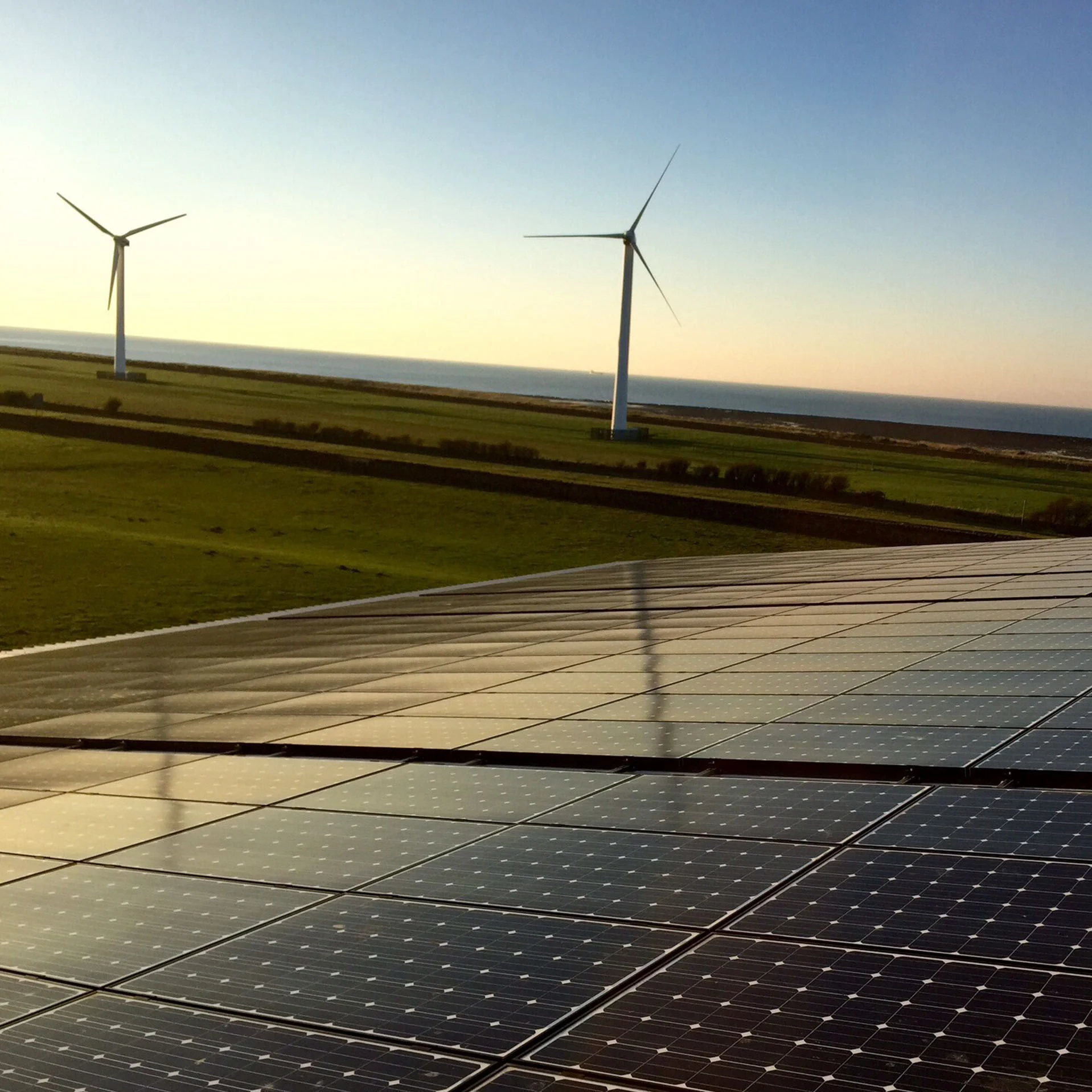 Panneaux solaires et éoliennes sur fond de ciel bleu