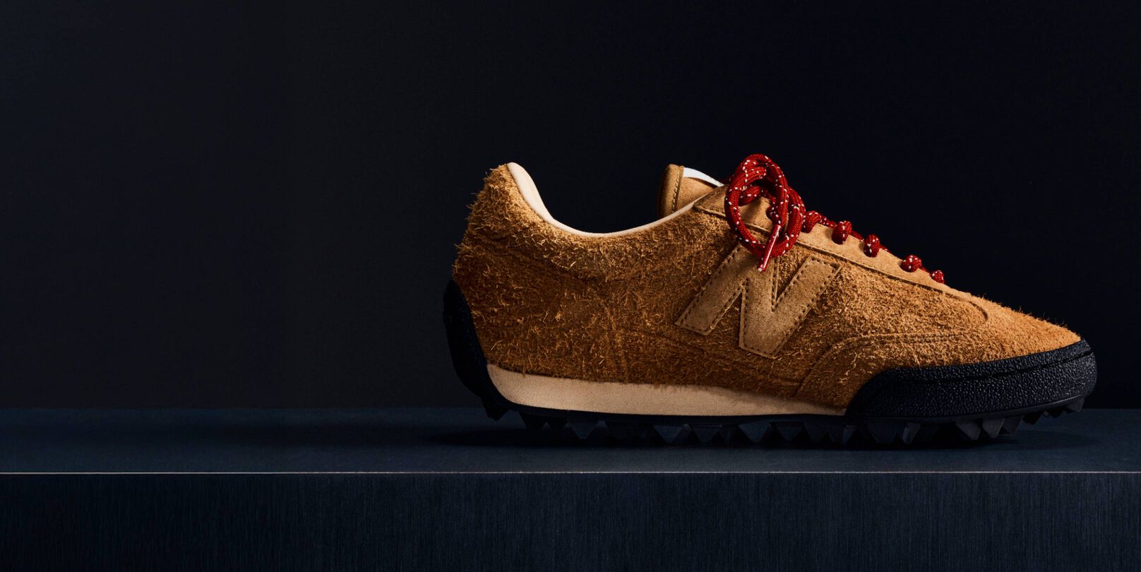 Une chaussure Gator Run en daim marron sur fond noir.