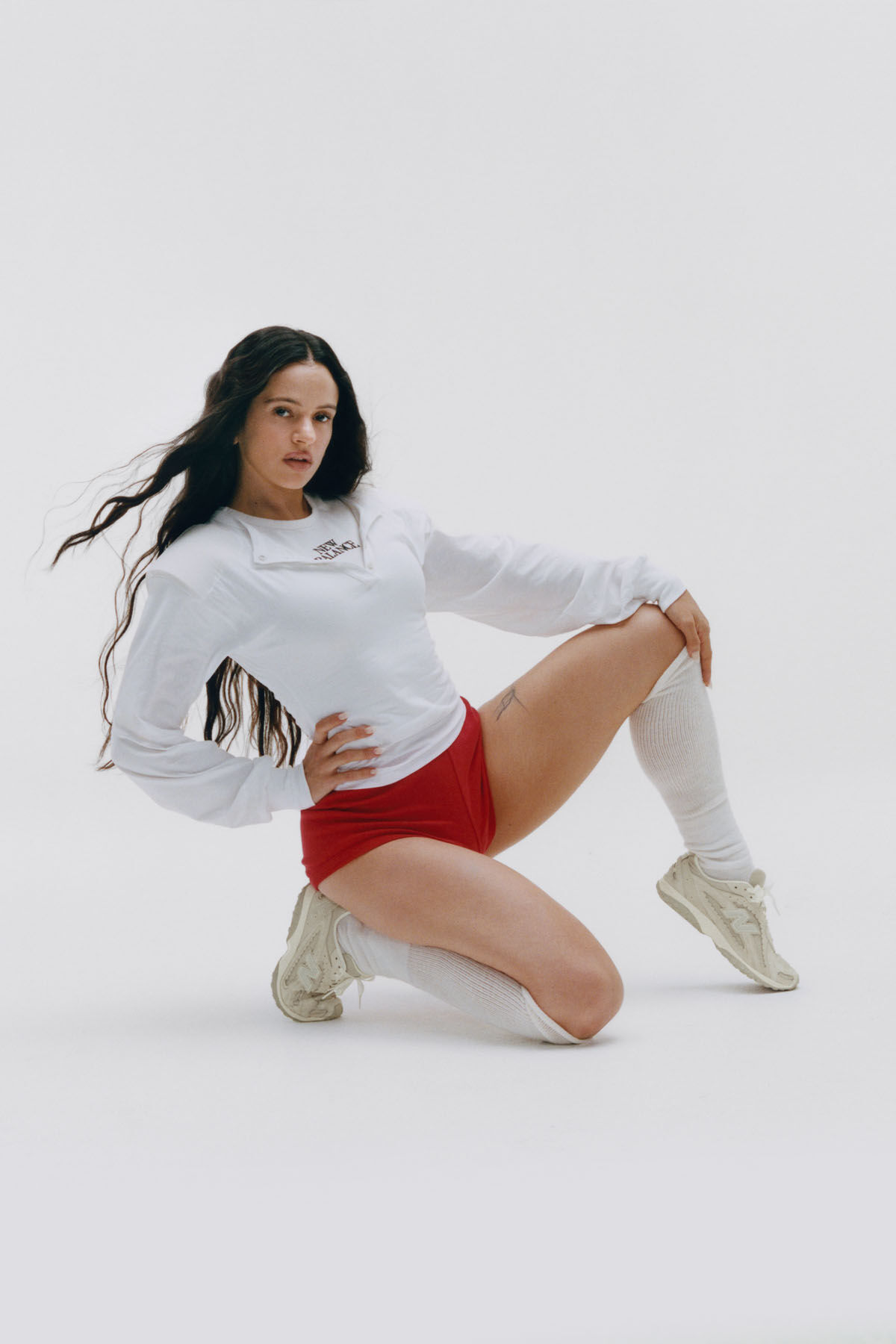 Rosal&iacute;a assise sur un fond blanc de studio.