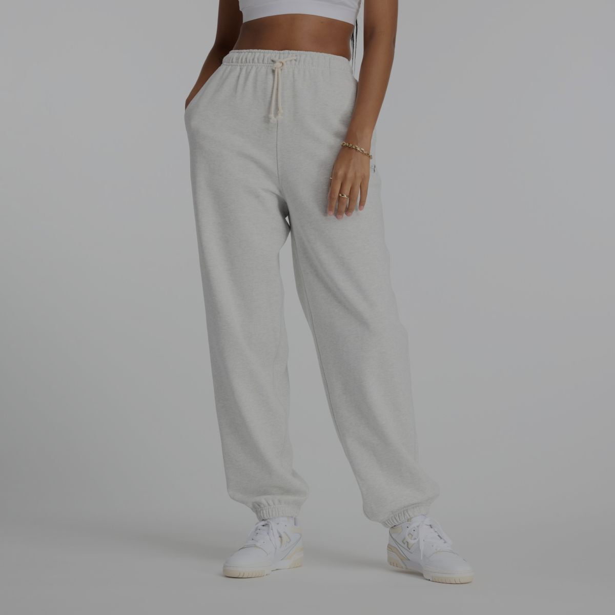 Une femme portant un pantalon de survêtement gris New Balance.