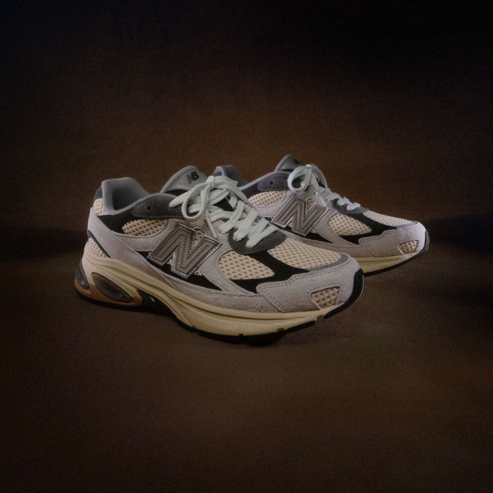 A grey shoe on a dark brown backdrop. 