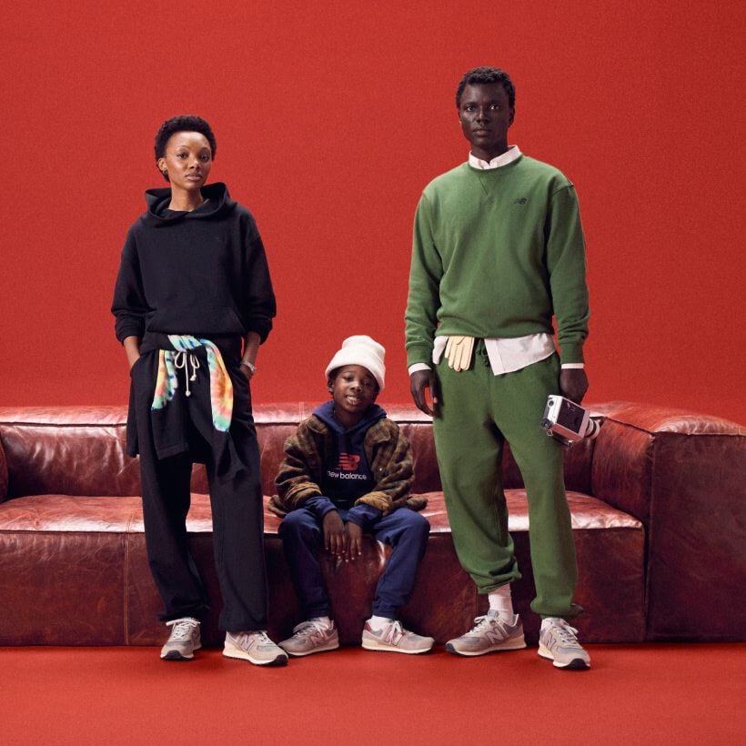 Family sitting around a red couch on a red background.