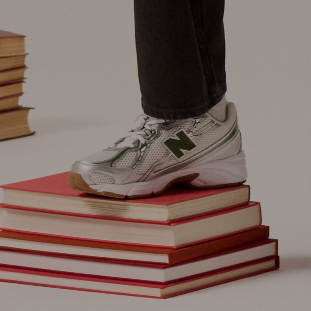 Un enfant avec son pied sur une pile de livres.