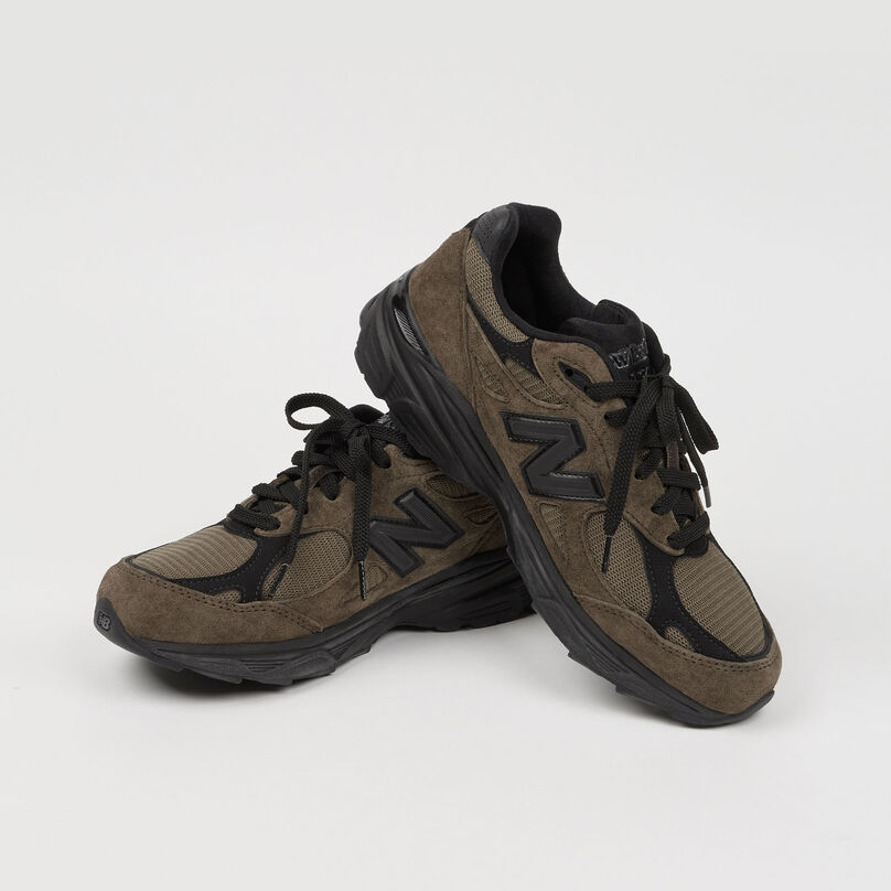 Paire de chaussures 990v3 posées sur un fond de studio gris