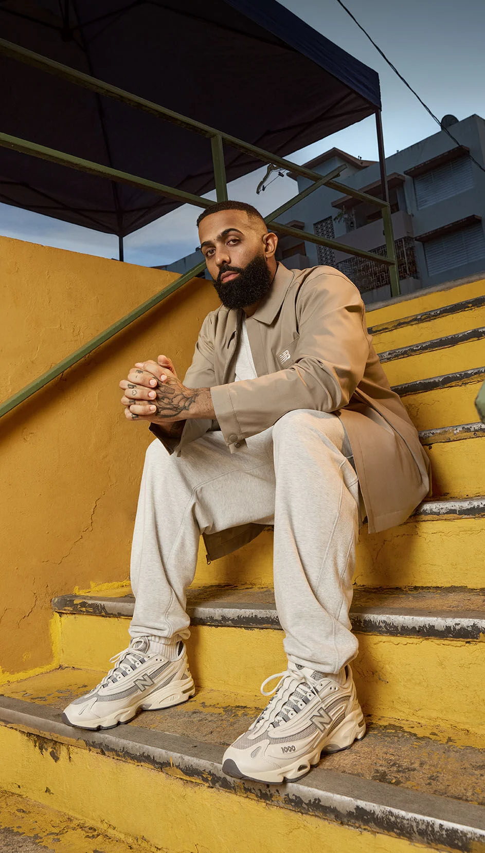 Eladio Carrion sitting, wearing a pair of New Balance 1000 shoes. 