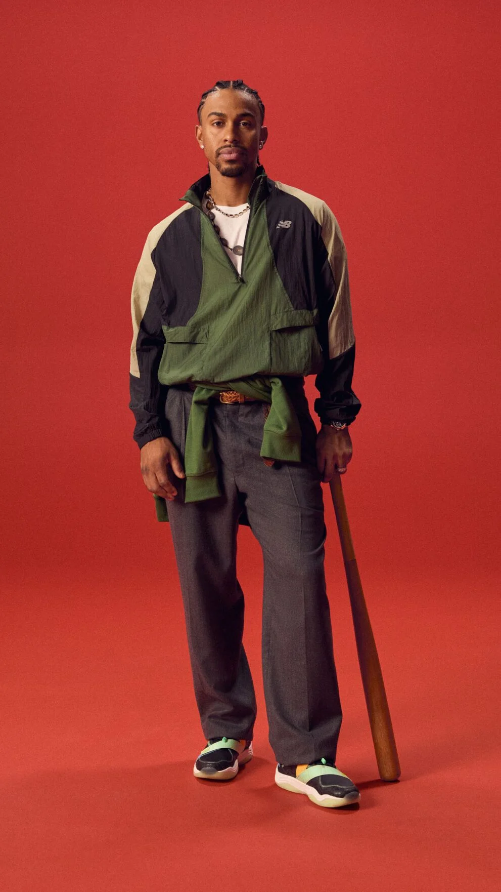 Athlète de baseball tenant une batte sur fond rouge.