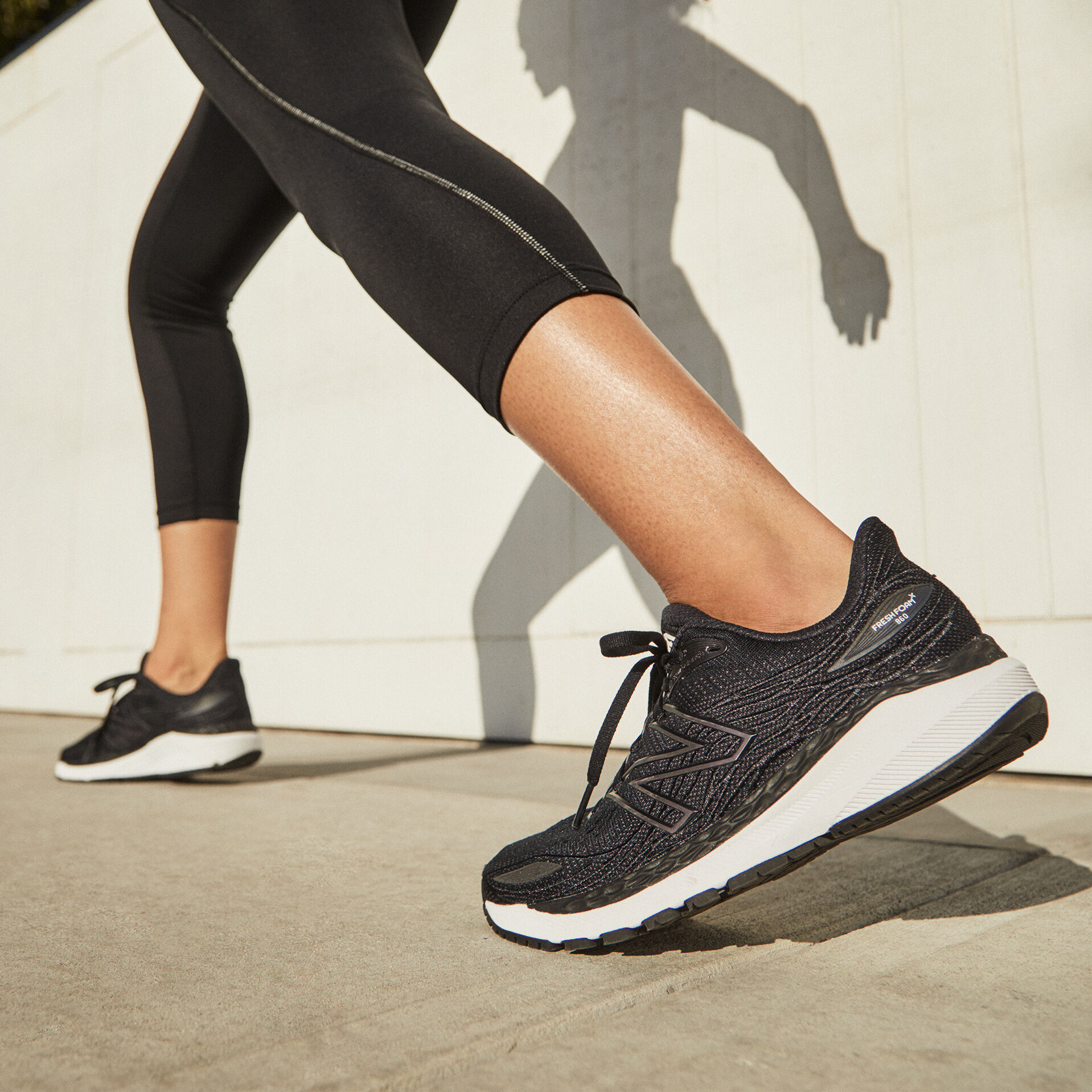 Vue des jambes d’un coureur portant un legging noir et des chaussures Fresh Foam 860v12 noires avec le talon légèrement vers l’avant
