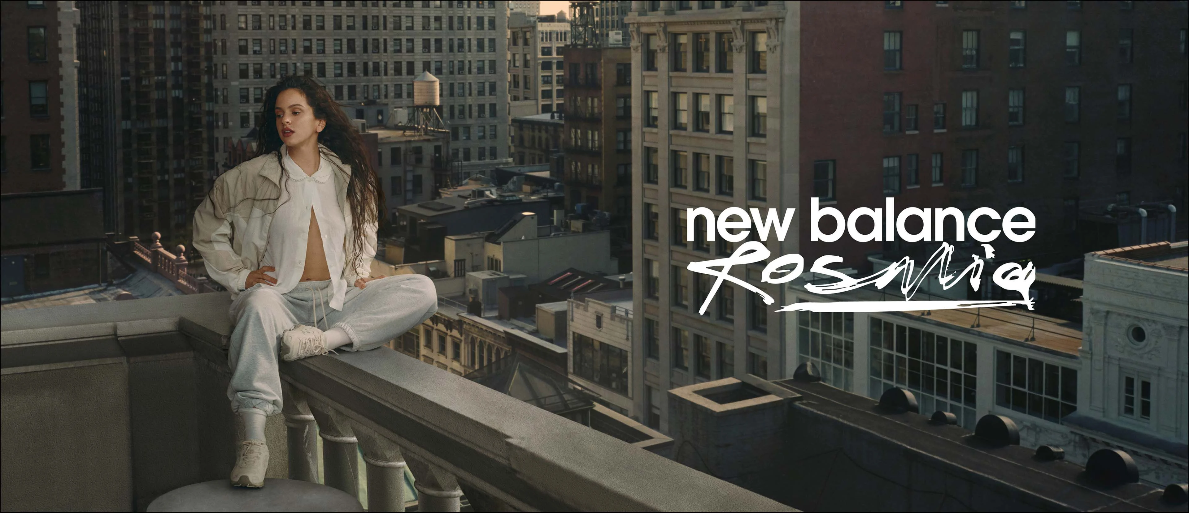 Rosalía sitting on a balcony overlooking the city.