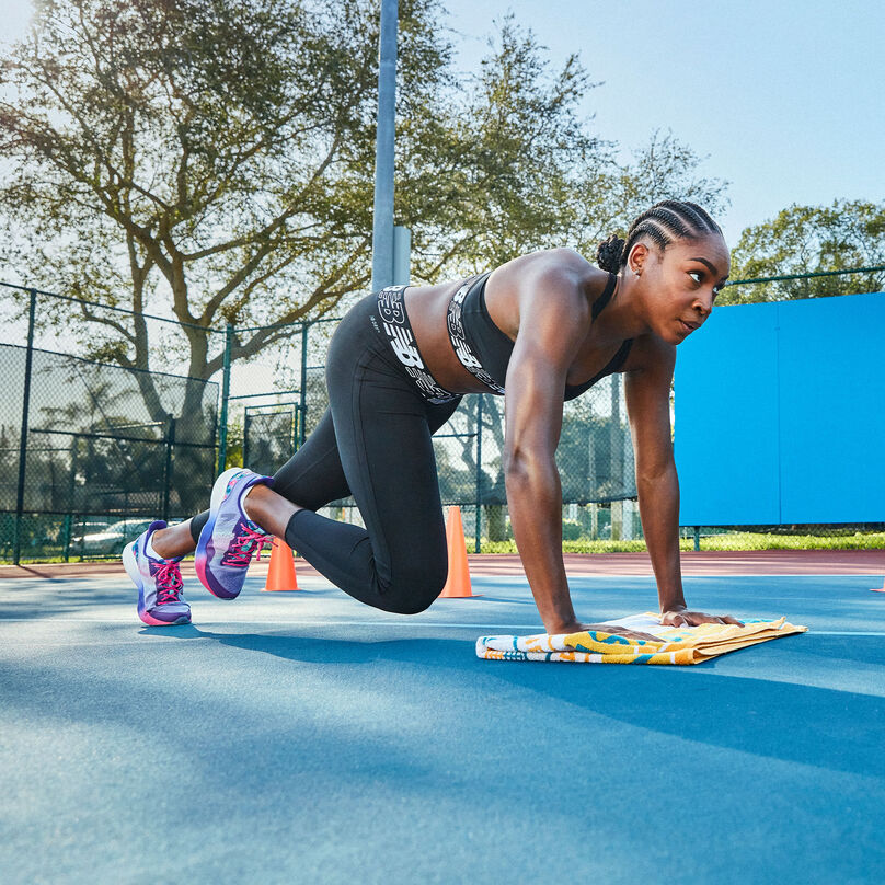 Coco Gauff training on a tennis court in a black matching set and multi-colored FuelCell Shift TRs