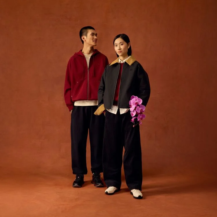 Man and woman standing up with the woman holding flowers. 