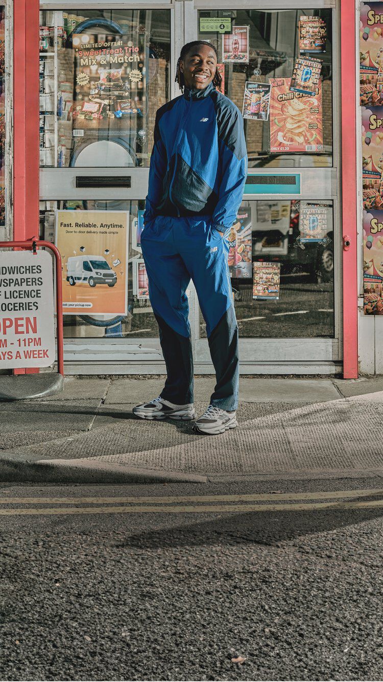 Eze standing outside of a store with his hands in his pockets. 