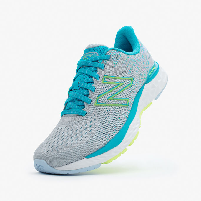 The blue shoe lifted up in the back with the toe on a grey background.