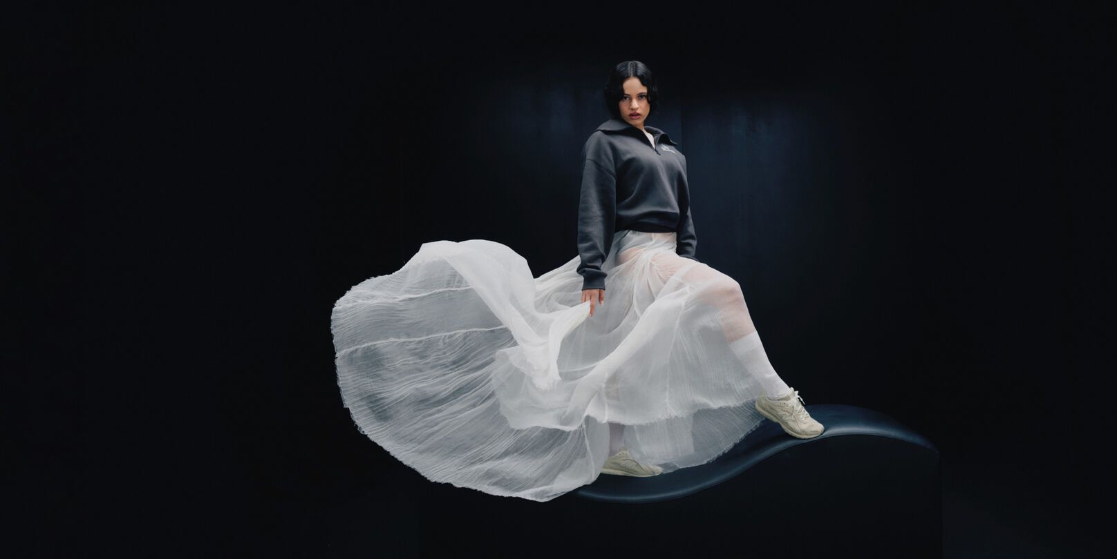 Rosal&iacute;a standing in front of a black studio backdrop. 