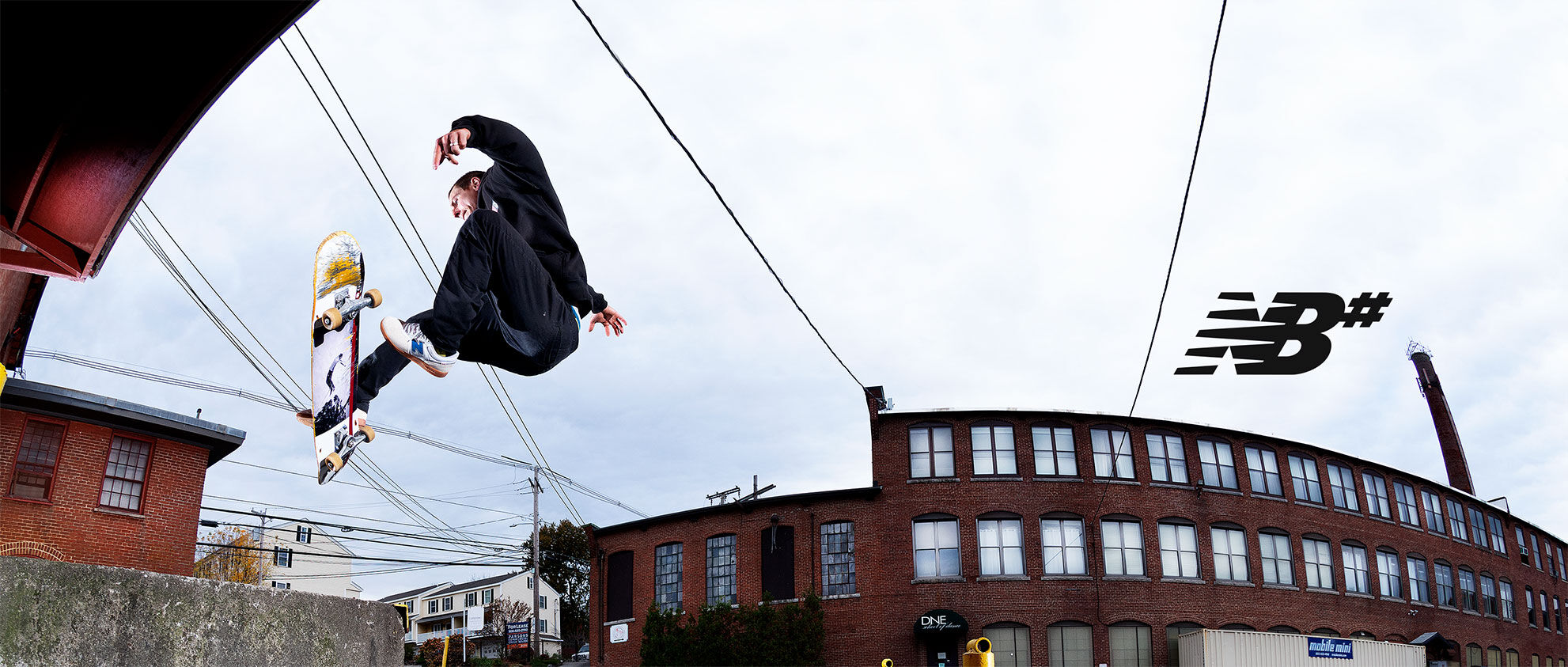 Brandon Westgate in the air performing a trick in an industrial background