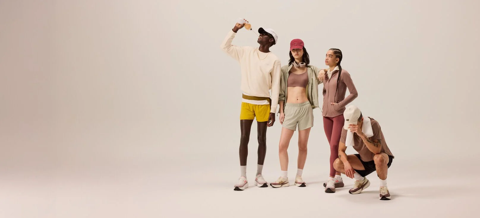 Group of young, adult runners standing next to each other on a beige background. 