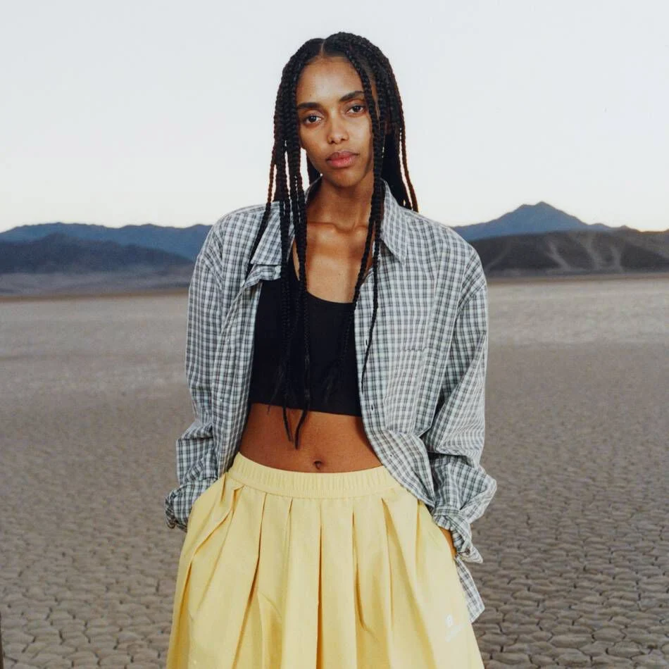 A woman standing in a desert environment. 