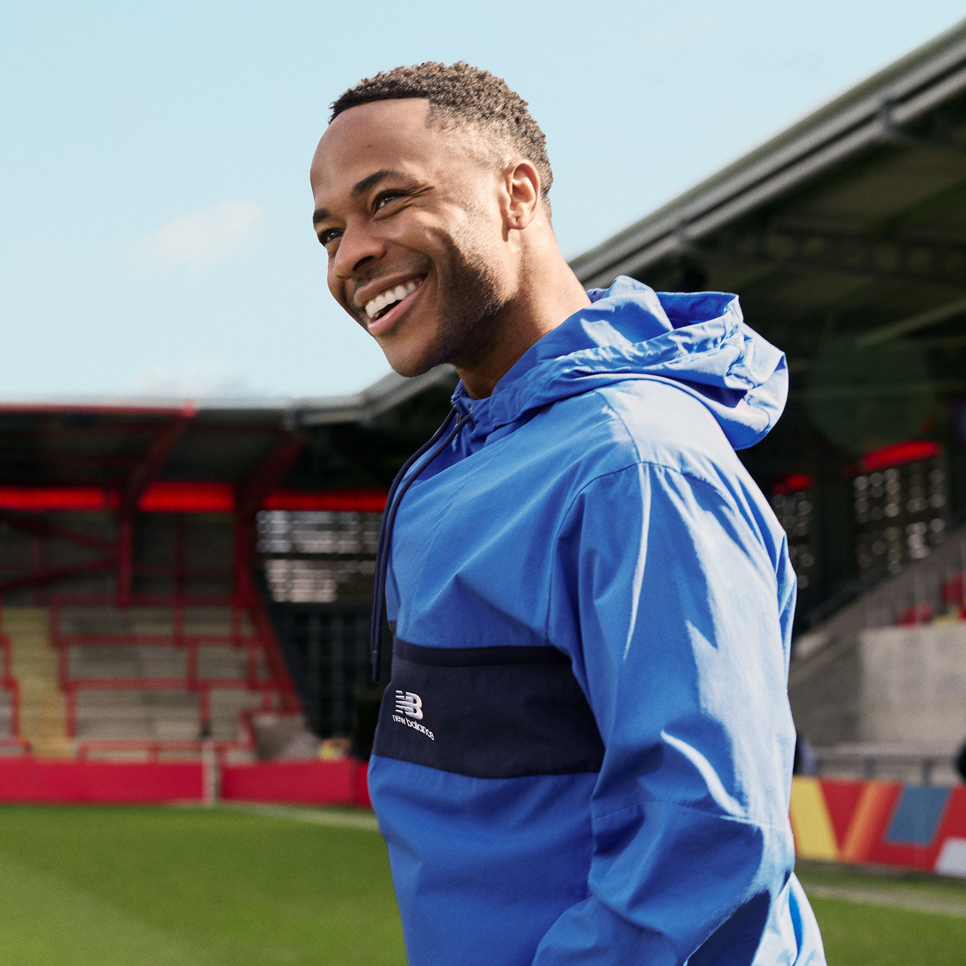 Photo de Raheem Sterling souriant, prise de la taille vers le haut