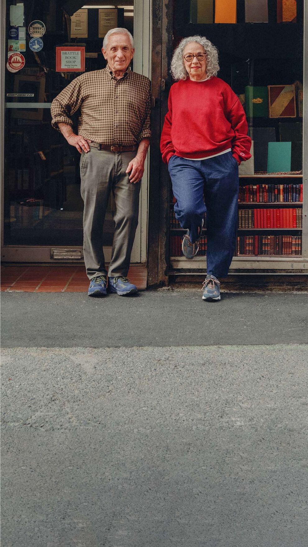 Un homme et une femme debout dans la rue devant une librairie.