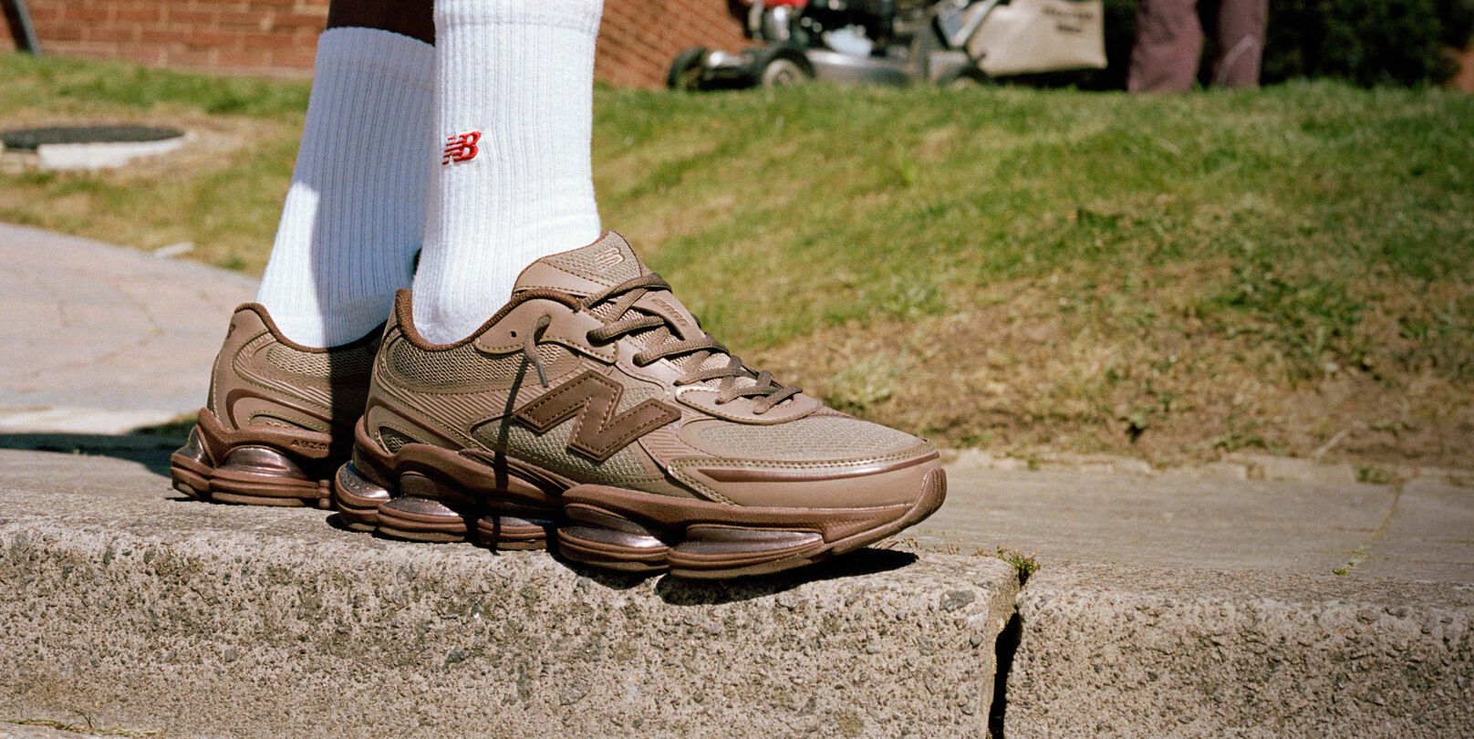 Image genoux contre terre de quelqu&rsquo;un portant des espadrilles New Balance brunes &agrave; l&rsquo;ext&eacute;rieur.