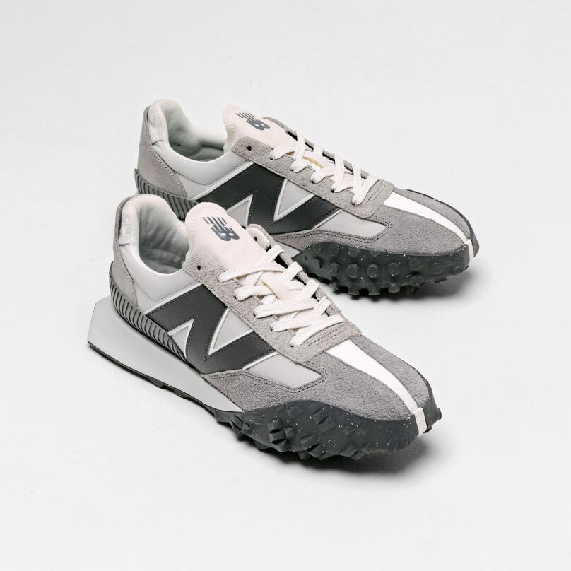 Paire de baskets grises XC-72 dans un décor de studio gris.