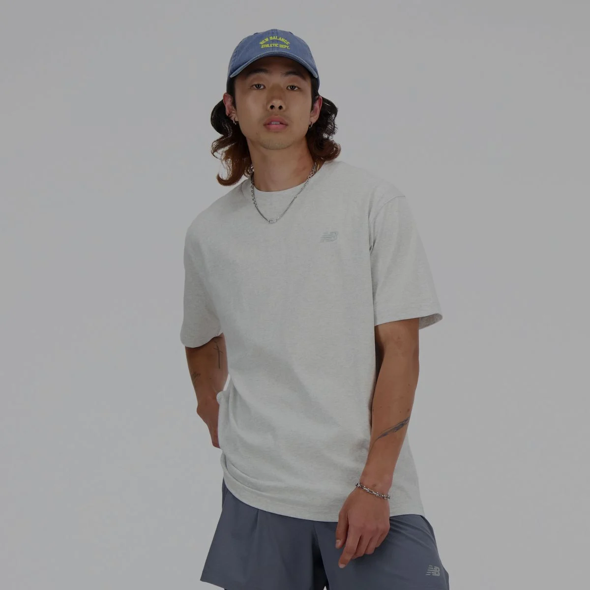 Un homme en t-shirt gris New Balance.
