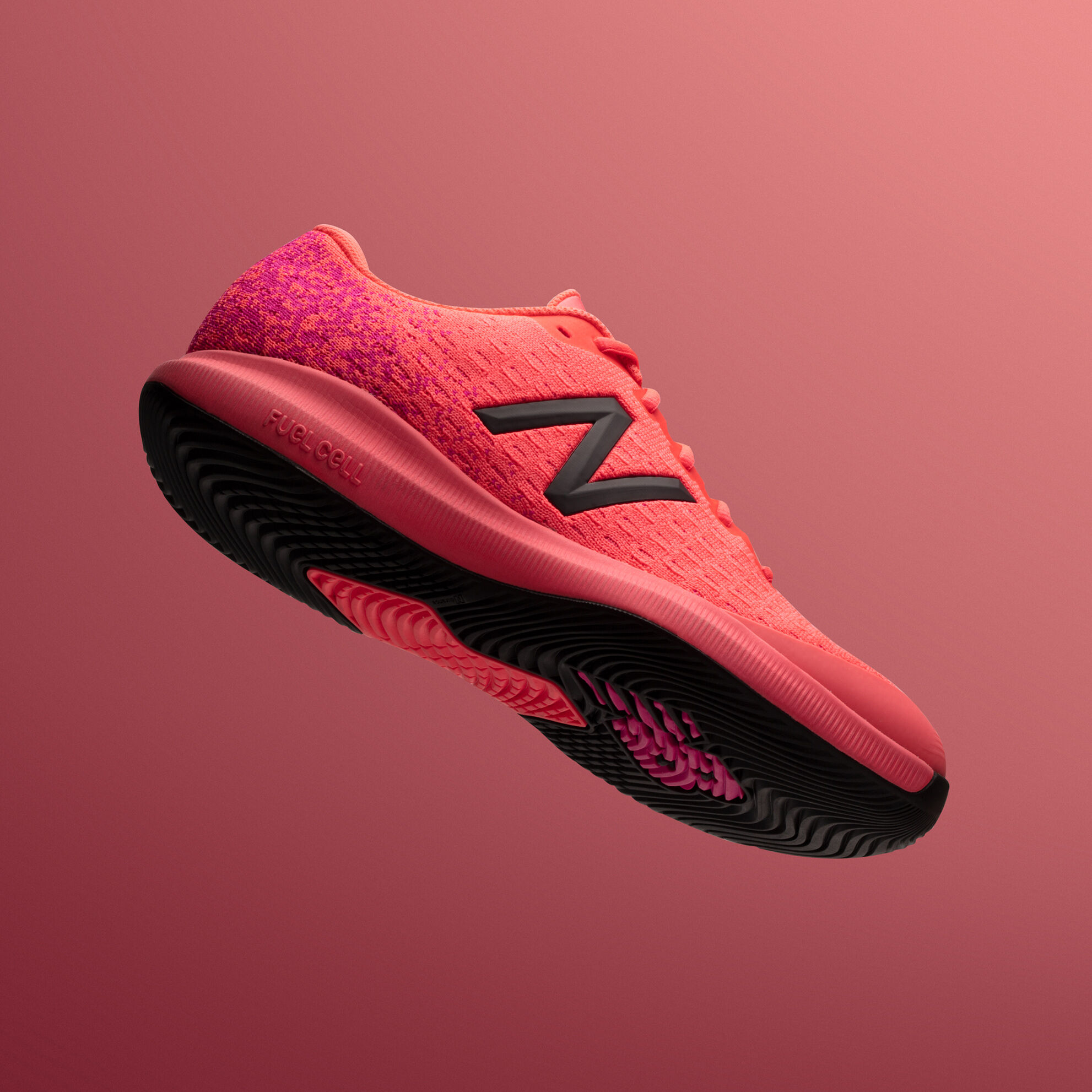 Side view of floating FuelCell 996 shoe on pink background