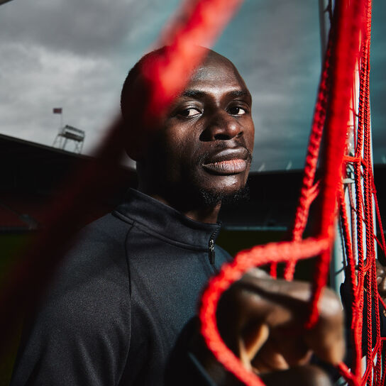 Joueur de football Sadio Mane sur un terrain de soccer sombre et boueux. h.