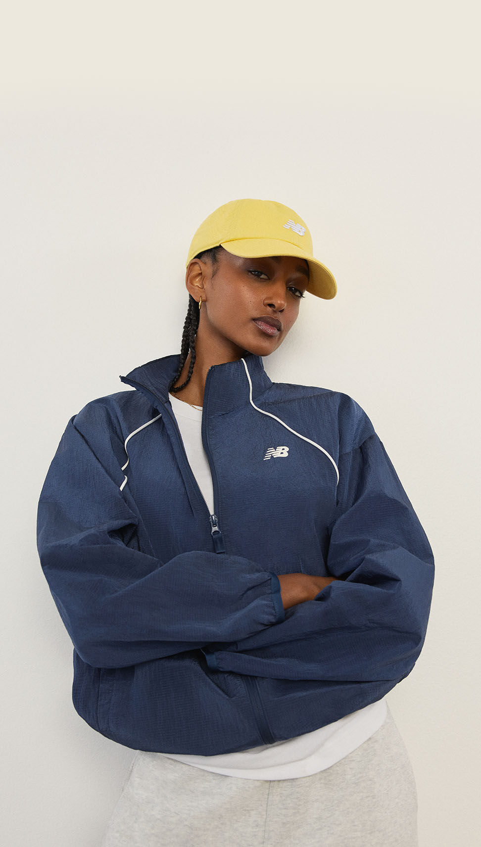 Une femme debout devant un mur blanc.