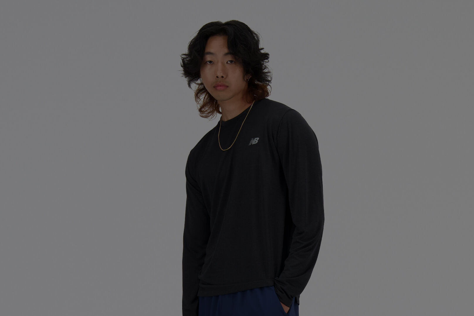 Homme vêtu d'un t-shirt New Balance noir à manches longues.