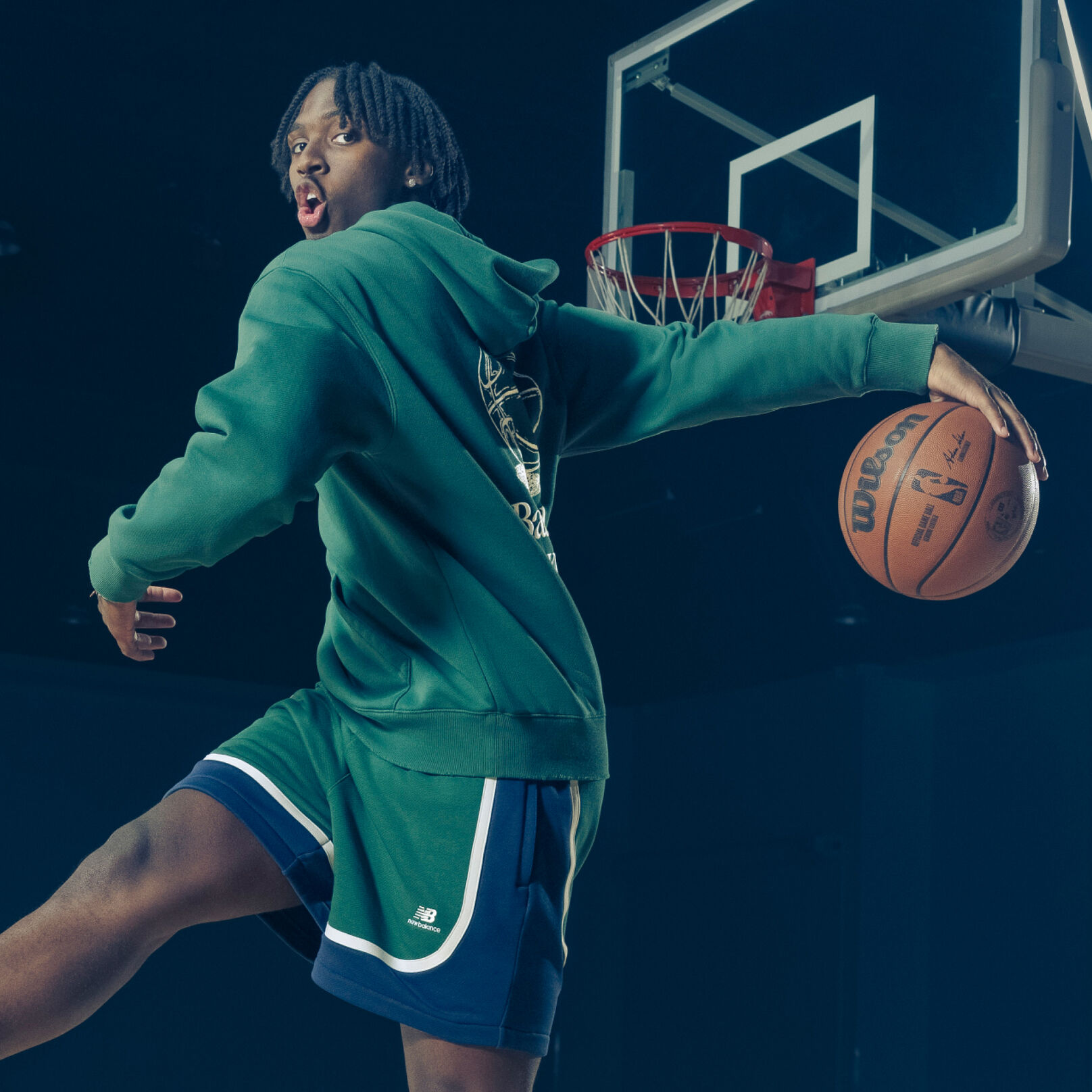 Tyrese wearing a green hoodie making a behind the back pass.