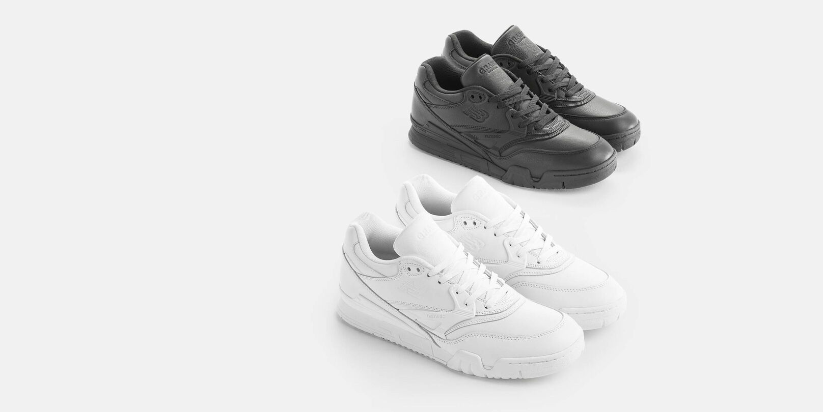 One pair of white 770 shoes and one pair of black 770 shoes in studio.