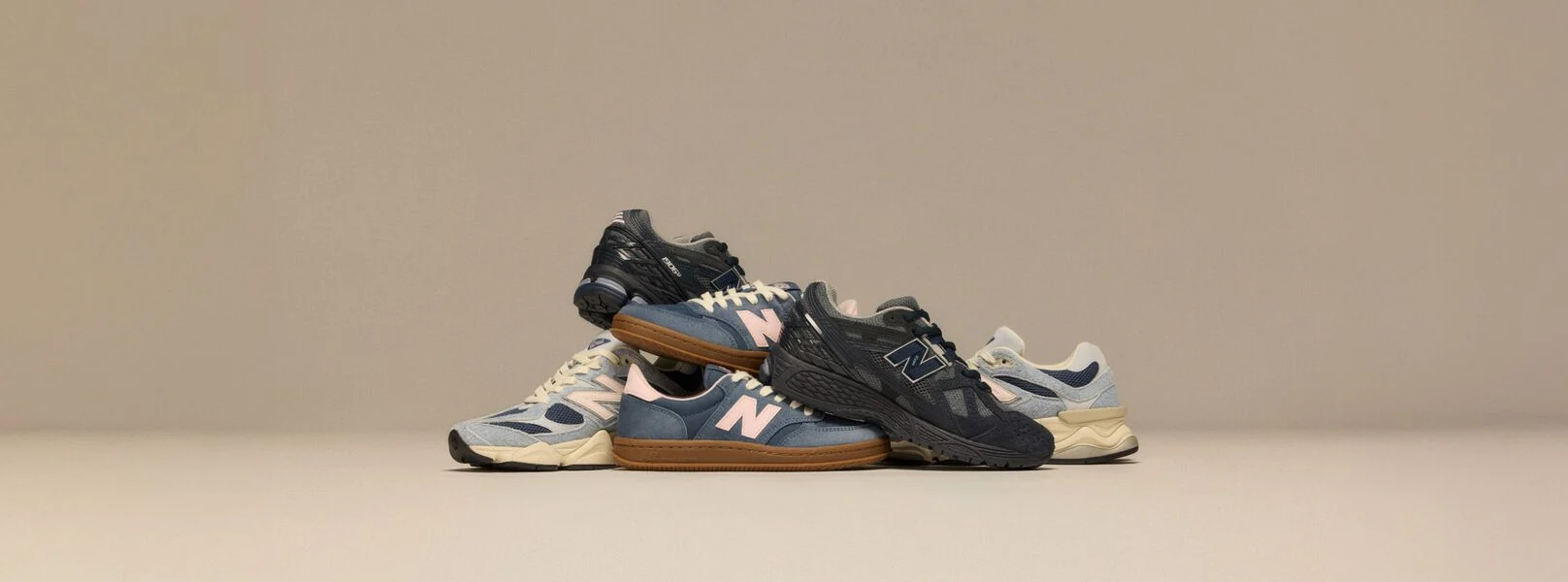 Pile de baskets New Balance sur fond beige