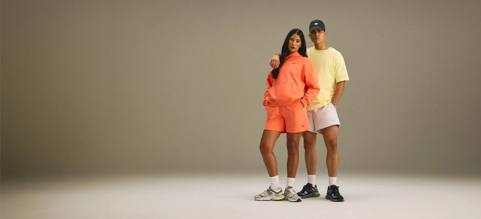 A man and woman standing together in a studio environment. 