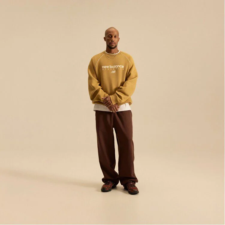 Image of Brian Reid in a New Balance outfit with a pale brown top in front of a beige background.