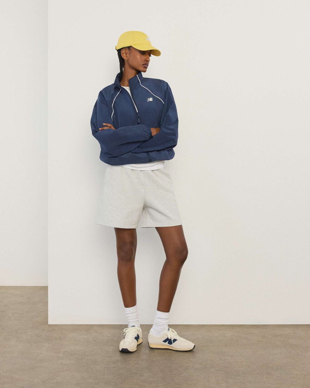 A woman standing in front a white wall.