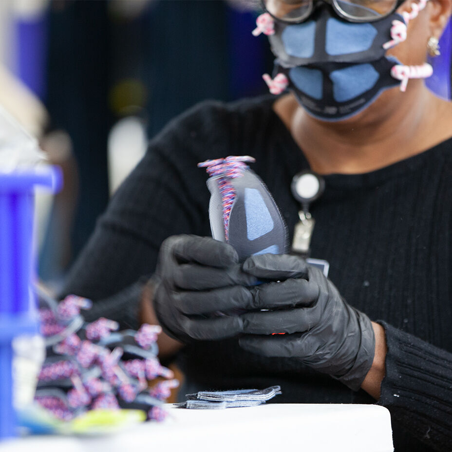 Un ouvrier d'usine assemble un masque facial