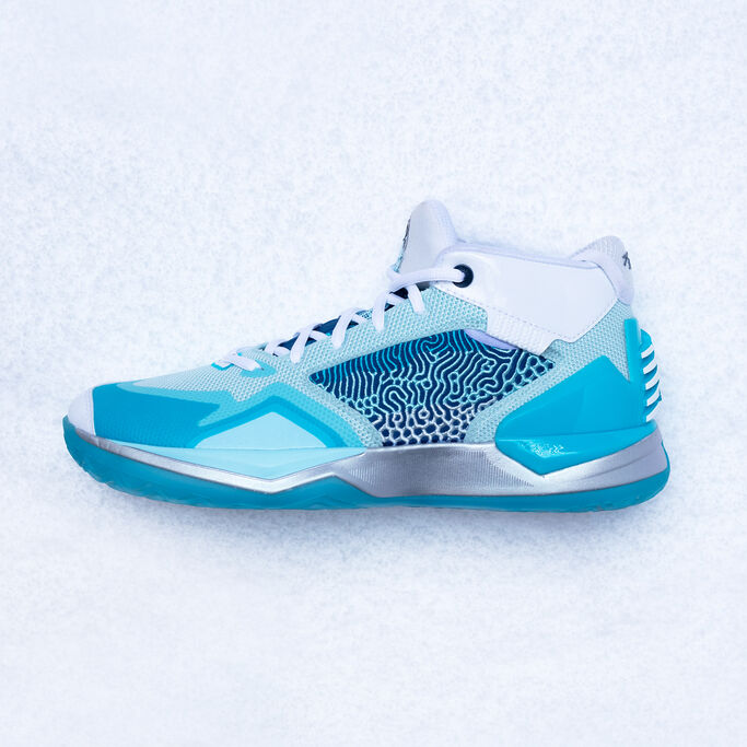 Profile view of the basketball shoe laying on snow.