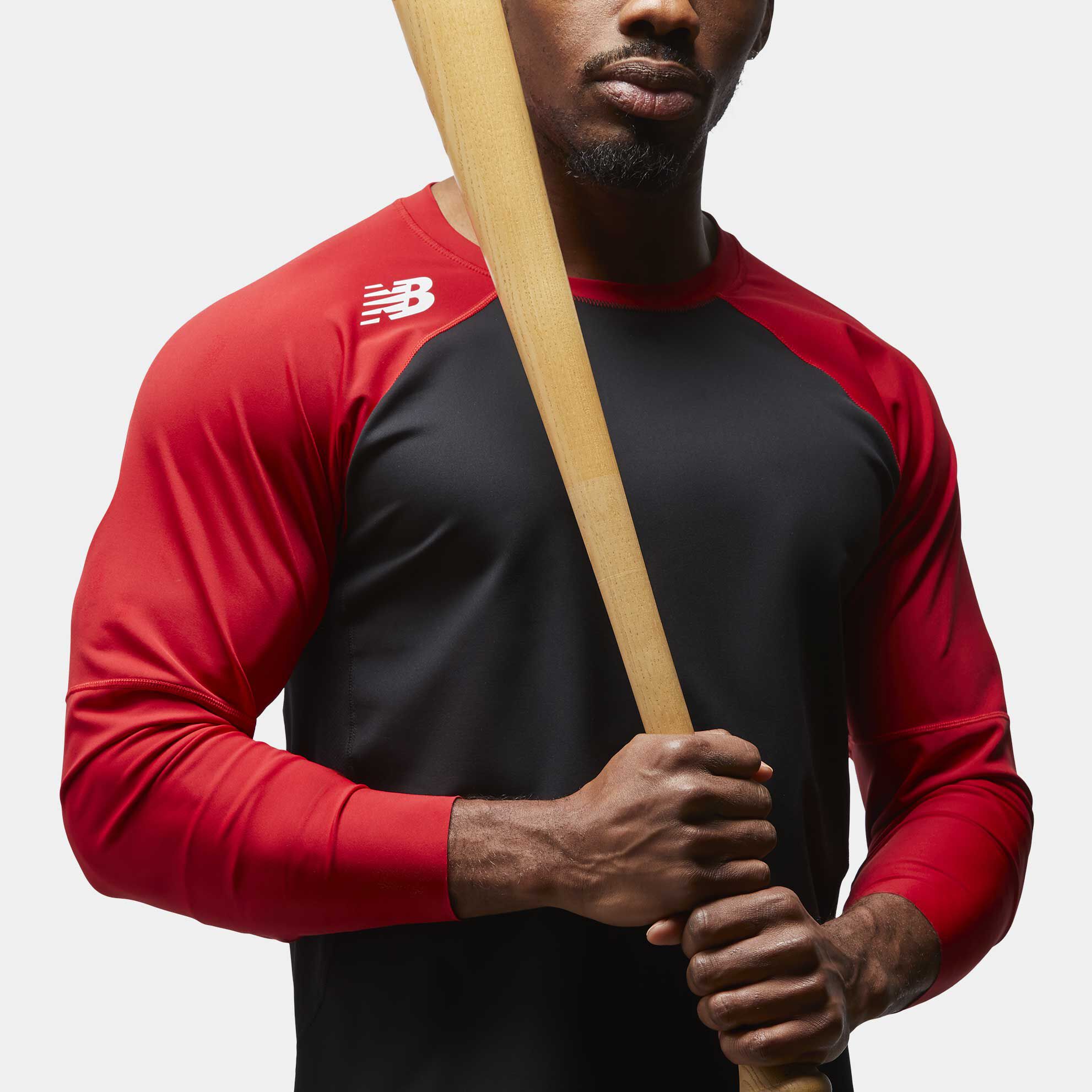 Man wearing red top and holding bat