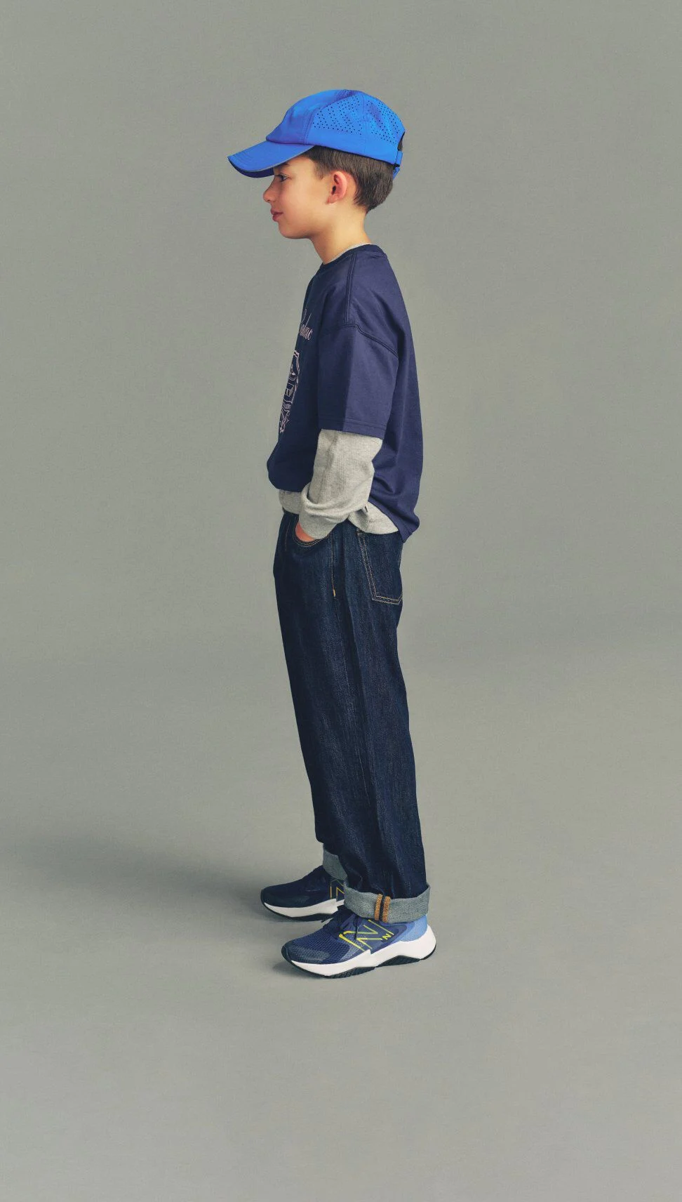 Kid wearing Rave Run shoes standing against a grey studio background.