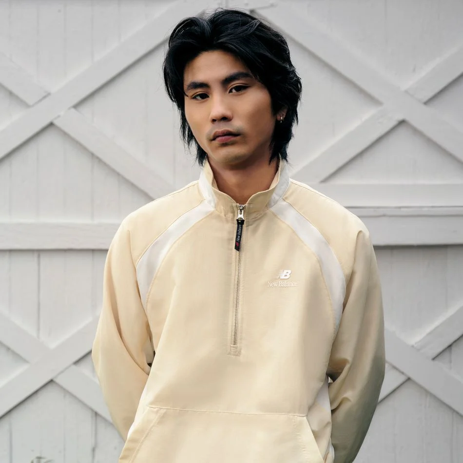 Un homme portant un pull marron clair.