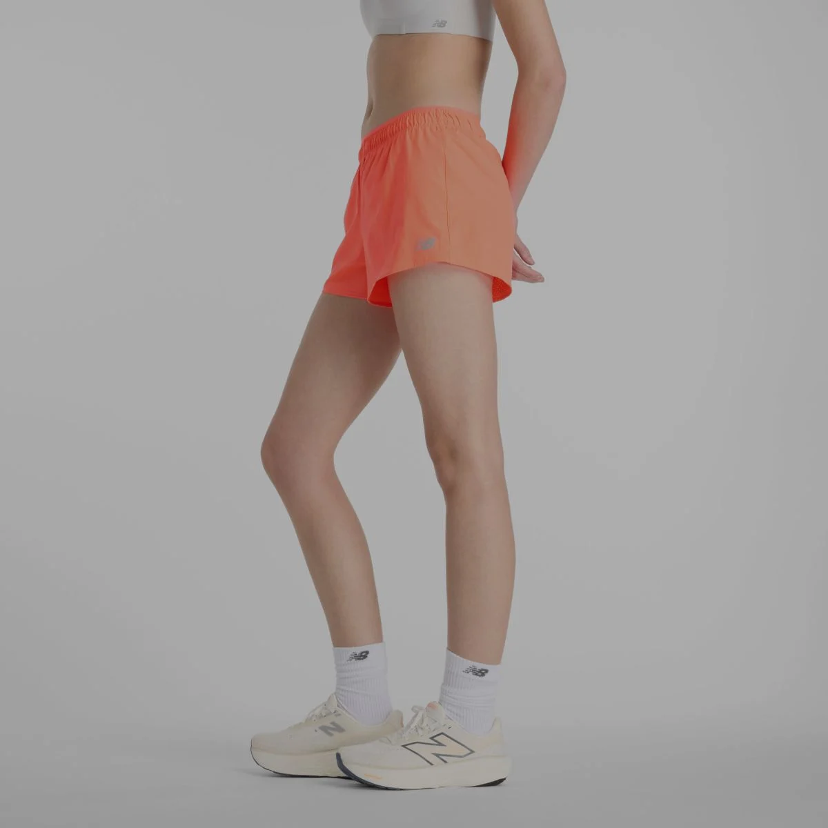 Une femme portant des shorts New Balance orange.