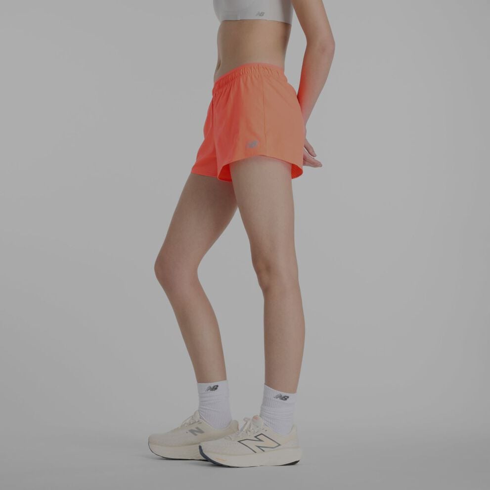 Une femme portant des shorts New Balance orange.