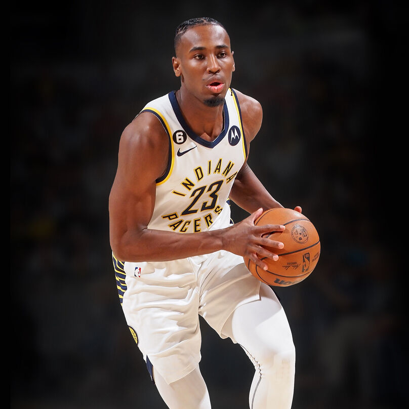 Aaron in his Pacers uniform dribbling up the court.